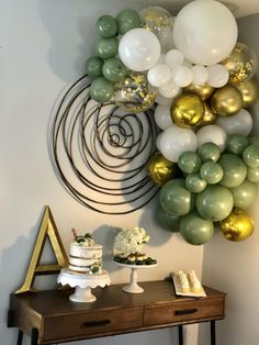 a table topped with cake and balloons next to a wall