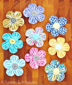 several different colored flowers sitting on top of a wooden floor