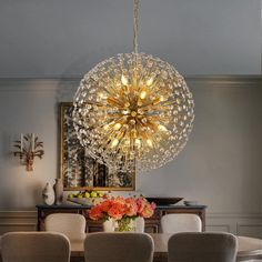 a dining room table with chairs and a chandelier hanging from it's ceiling