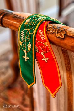 a red and green ribbon on the back of a chair with gold trimmings