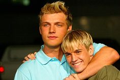 two young men hugging each other in front of a car