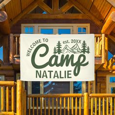 a welcome sign to camp natale on the front porch of a log cabin