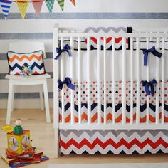 a white crib with orange, blue and grey chevrons