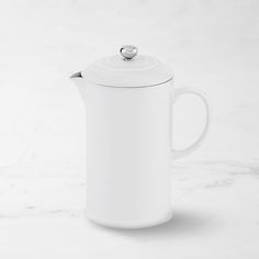 a white coffee pot sitting on top of a marble counter