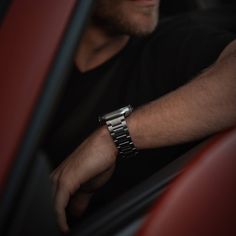 a man wearing a watch sitting in a car