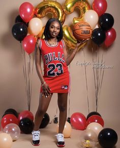 a woman posing for a photo with balloons and basketballs