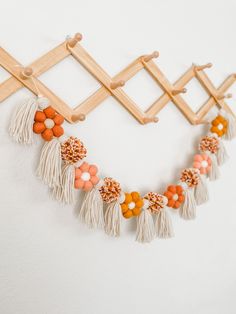 an orange and white beaded necklace hangs on a wall