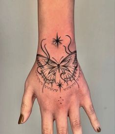 a woman's hand with a butterfly tattoo on it