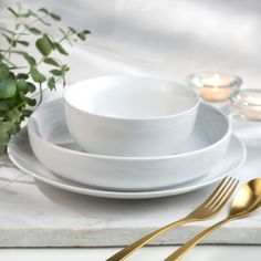 white plates and silverware on a marble table