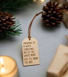 a christmas ornament with a poem on it next to candles and pine cones