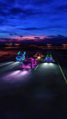 three cars driving down the road at night with their lights on and one car in the foreground