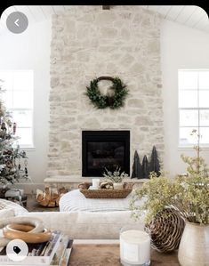 a living room filled with furniture and a christmas tree in front of a fire place