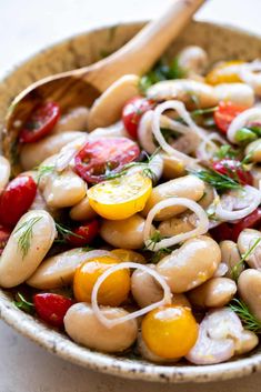 a close up of a bowl of food with tomatoes, onions and other things in it