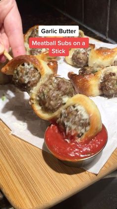 someone is dipping meatballs on a stick