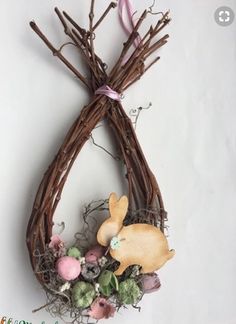 an easter wreath made out of twigs with bunny and eggs in the center on a white background