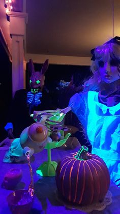 A creepy glowing Alice serves tea to a sharp-toothed March Hare. Alice In Wonderland Halloween Decor Outdoor, Alice And Wonderland Halloween Decor, Creepy Wonderland, Creepy Alice In Wonderland Art, Halloween Alice In Wonderland Party, Alice In Wonderland Haunted House Ideas, Diy Alice In Wonderland Halloween Decorations, Black Light Alice In Wonderland