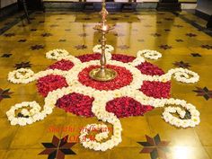 the floor is decorated with flowers and a metal candle holder on one side, surrounded by red and white petals