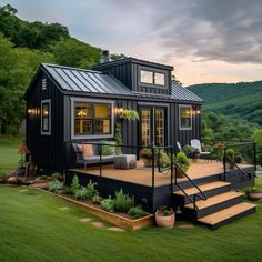 a small black house sitting on top of a lush green field