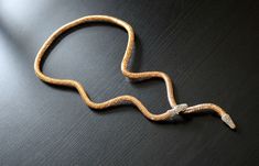 "The necklace will adorn any woman who is not afraid to show her preference for extravagant jewelry. Long snake choker necklace made of gold metal tube / the ends of the necklace - the head and tail of the snake are made of alloy, nickel and lead free. The tube contains a flexible steel wire that allows to change the shape of the necklace. The snake's head has a magnet. The head and tail of the snake are covered with silver rhinestones. The length of necklaces 90 cm ( 35.43\") . Tube diameter 1 Silver Snake Necklace For Party, Metal Snake Chain Choker, Metal Snake Shape Necklace, Adjustable Metal Snake Shape Necklace, Adjustable Metal Snake Shape Necklaces, Metal Snake Chain Necklace For Gift, Silver Adjustable Snake Chain Necklace, Bendable Necklace, Ouroboros Jewelry