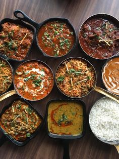 many different types of food in pans on a table