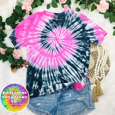 a pink and blue tie dye shirt next to some flowers