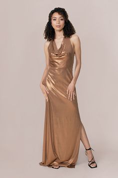 a woman in a gold dress posing for the camera