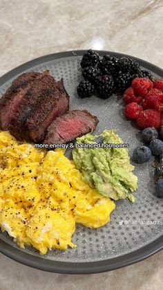 a plate with eggs, meat and fruit on it