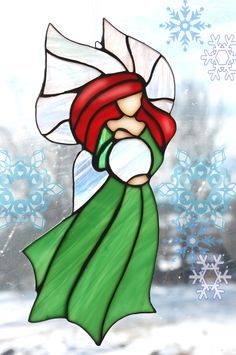 a stained glass window depicting a woman with red hair and green dress in front of snowflakes