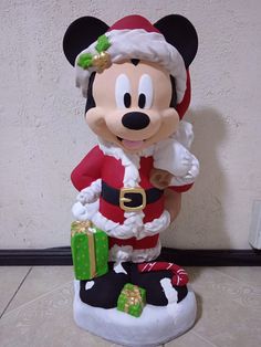 a mickey mouse figurine dressed as santa clause