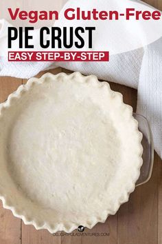 an uncooked pie crust sitting on top of a wooden table next to a white towel