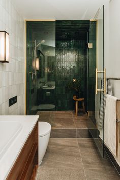 a bathroom with green walls and tile flooring