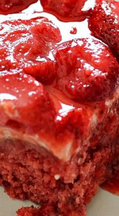 a close up of a piece of cake on a plate with strawberries in it