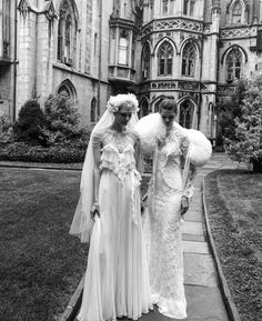 two women in wedding dresses are standing outside