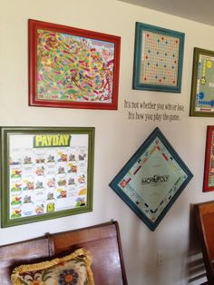 a wall with several framed games on it, including monopoly and scrabbles