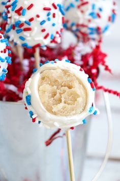 red, white and blue sprinkled cake pops in a bucket