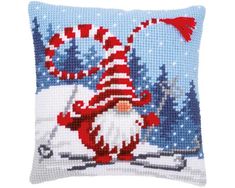 a cross stitch pillow with an image of a gnome on skis in the snow