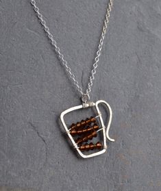 a silver necklace with brown beads on it