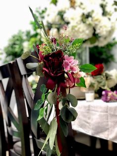 a bouquet of flowers sitting on top of a wooden table next to a white table cloth