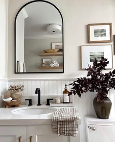 a bathroom sink with a mirror above it next to a white toilet and counter top