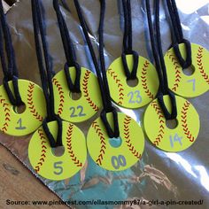 baseball themed tags with numbers on them are sitting on a piece of plastic wrapped in black string