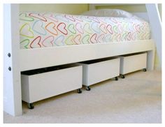 a white bed with drawers underneath it in a small room next to a wall and carpeted floor