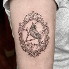 a bird sitting on top of a tree branch in a circle frame tattoo design for women