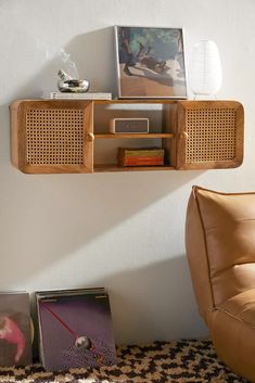 a living room with a brown leather chair and wooden shelves on the wall above it