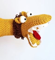 a crocheted hand with a fake alligator's head and teeth on it