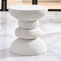 a stack of white rocks sitting on top of a marble table next to a window