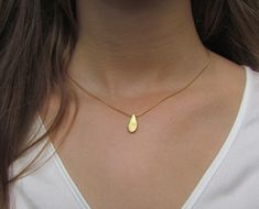 "This hand made teardrop pendant necklace has an effortless, earthy allure. The matte 18k gold plated brass pendant hangs at the base of a delicate 14k gold filled chain. This is the perfect necklace to pair with any casual outfit adding a bohemian vibe. Wear this alone, or layer it with your other favorites for a personalized eclectic look. ❉ F A C T S total length : 16\"/ 42 cm teardrop length: 1\"/ 2.54 cm teardrop width: 0.45\"/ 1.1 cm You will receive the necklace in a gift box ready to be Minimalist Teardrop Pendant As A Gift, Minimalist Teardrop Pendant For Gift, Minimalist Teardrop Pendant Drop Gift, Minimalist Gold Pear Drop Necklace, Gold Pear-shaped Drop Necklace For Gift, Gold Teardrop Necklace With Delicate Chain, Everyday Delicate Teardrop Drop Necklace, Gold Teardrop Drop Necklace In Dainty Style, Gold Teardrop Drop Necklace For Gift