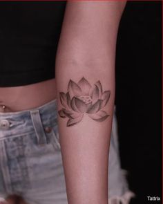 a woman's arm with a lotus tattoo on the left side of her body