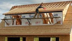 a man standing on the roof of a house under construction