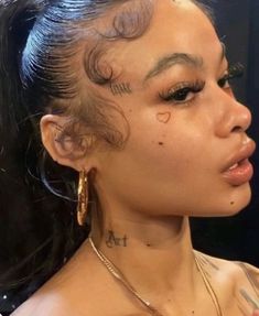 a close up of a person with tattoos on her face