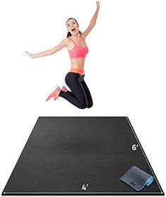 a woman jumping up into the air on top of a mat with a cell phone